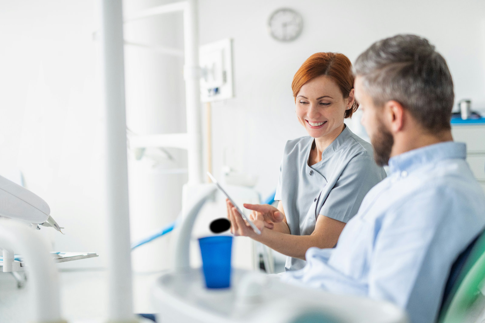 Two people in a dentists office discuss benefits of amalgam separators