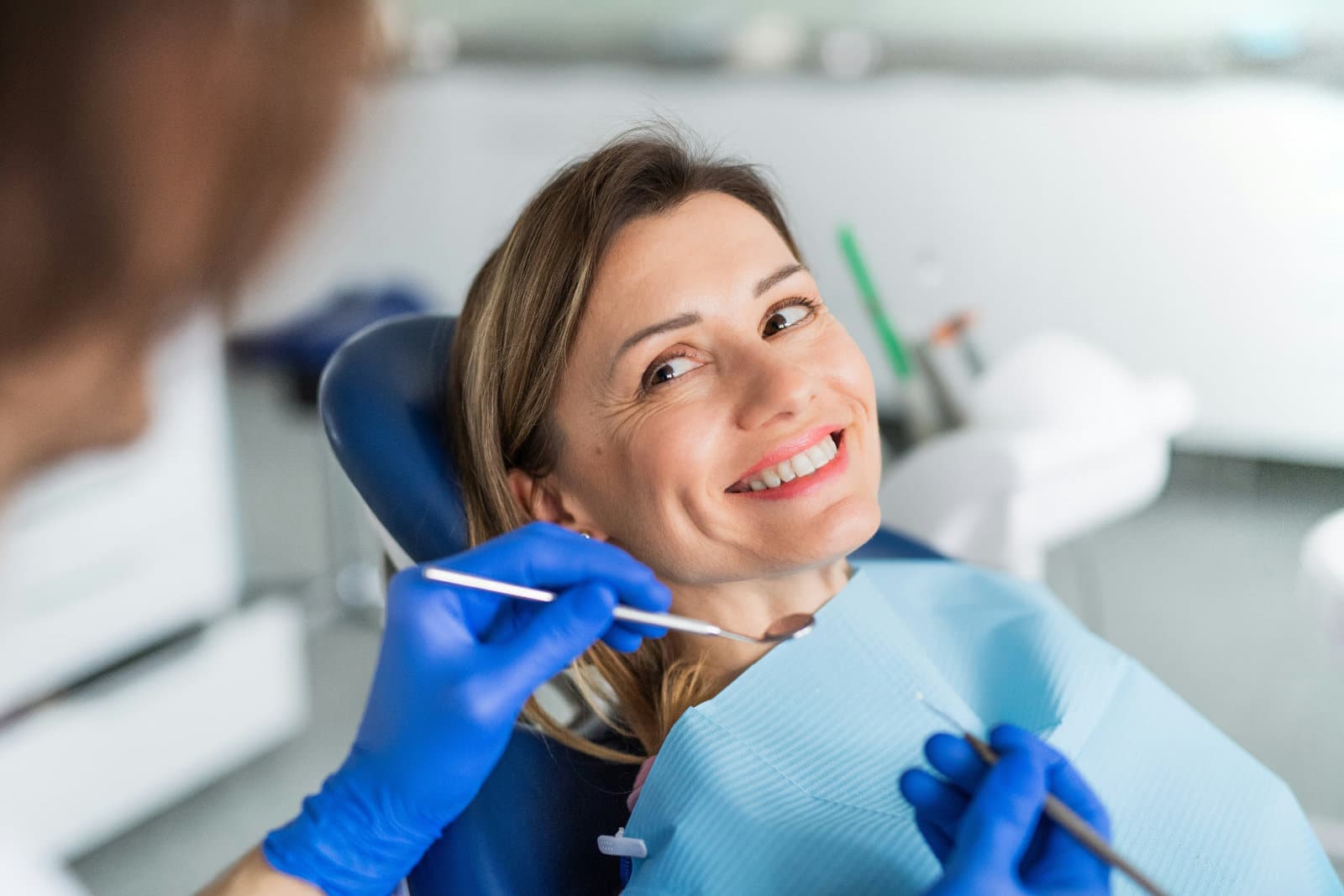 A woman in a dentist's office, smiling
