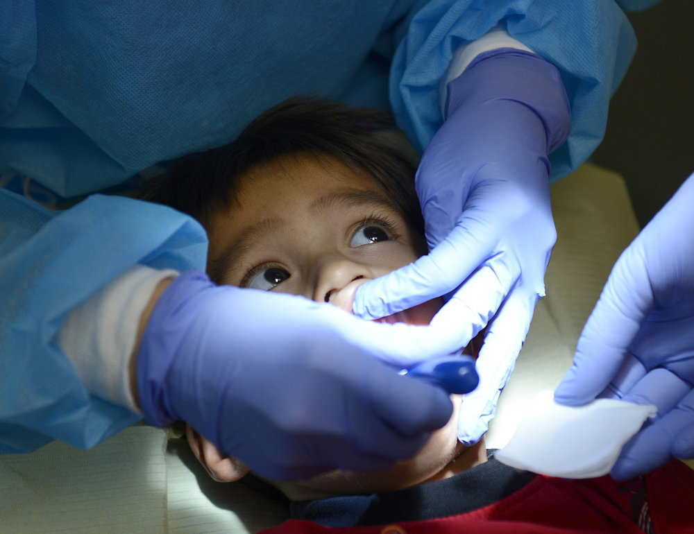 Two year-old Pedro Julio has his teeth brushed during a visit to Healthy Smiles for Kids in Garden Grove. The story is about new guidelines for children that now recommend starting with flouride toothpaste once the first baby teeth come in as a way of preventing cavities.